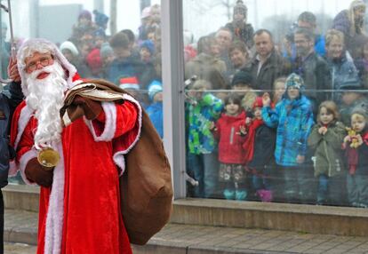 Niños observan la llegada de un Papa Noel al aeropuerto de Dresde, Alemania.