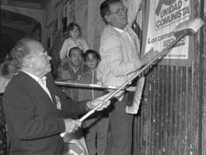 Santiago Carrillo y Juli&aacute;n Ariza pegan un cartel de su partido.