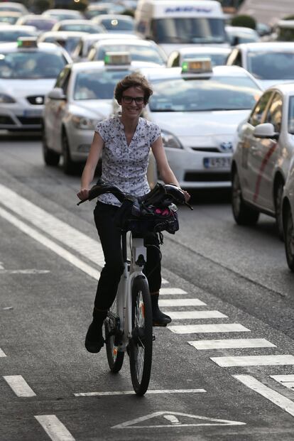 "Estoy encantada", dice una usuaria de BiciMad, circulando con la bici eléctrica por el carril bici de la calle Alcalá.