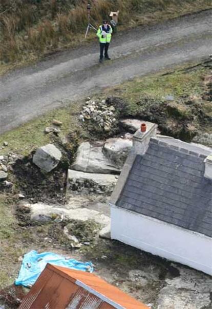 Un policía irlandés vigila la casa donde fue asesinado Denis Donaldson.