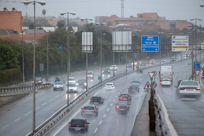 Varios coches circulan bajo la lluvia en Sevilla, este sábado.