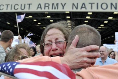 Una madre abraza a su hijo a su llegada a la base aérea de Connecticut.