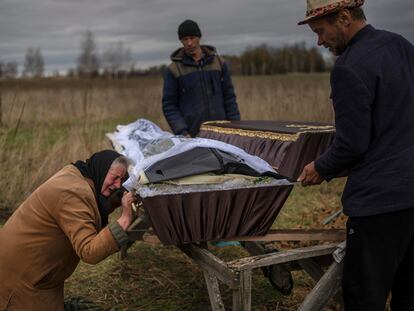 Una mujer llora mientras sostiene el ataúd de su hijo asesinado por soldados rusos, 30 de marzo en Bucha (Ucrania).