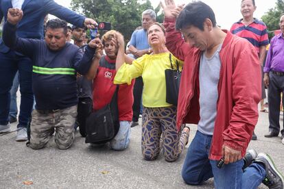 Vecinos rezan por el hombre al que habían colocado una carga explosiva en el pecho en las calles de Guayaquil, este jueves.
