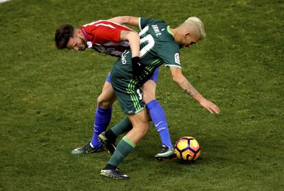 El centrocampista del Atlético de Madrid Saúl Ñíguez, lucha por el balón con Dani Ceballos, del Real Betis, durante el partido de la decimoctava jornada de Liga que disputan en el estadio Vicente Calderón de Madrid.