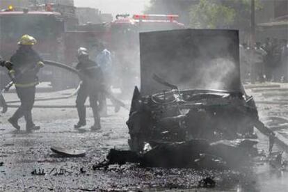 Bomberos iraquíes extinguen el fuego tras la explosión, ayer, de un coche bomba en el centro de Bagdad.