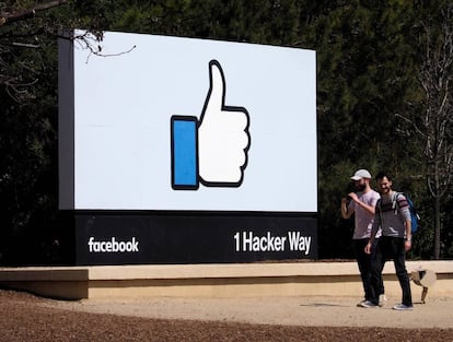 Dos hombres caminan junto a un icono de Facebook en Menlo Park, California, EE.UU., el 30 de marzo del 2018.