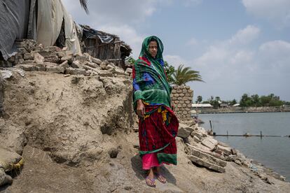 Lipika se para frente a los escombros de lo que fue su casa, en Pratapnagar, Satkhira. El ciclón Amphan, del 16 de mayo de 2020, la destrozó y la hundió en el río. Actualmente, no tiene
dinero para construir otra nueva y vive con su familia en una casa temporal.