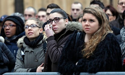 Moça chora enquanto assiste à homenagem aos policiais assassinados em Paris.