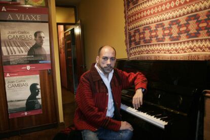 El pianista Juan Carlos Cambas, apoyado en un piano.