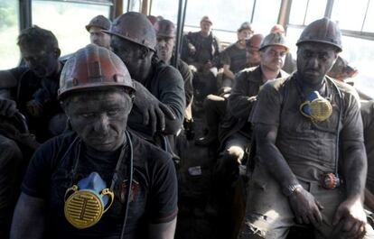 Un grupo de mineros en un autob&uacute;s que les lleva de la mina de Zasyadko a la ciudad de Donetsk. / Viktor Drachev (AFP) 