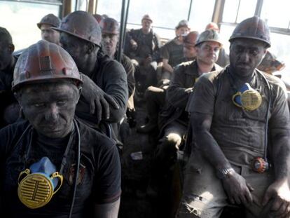 Un grupo de mineros en un autob&uacute;s que les lleva de la mina de Zasyadko a la ciudad de Donetsk. / Viktor Drachev (AFP) 