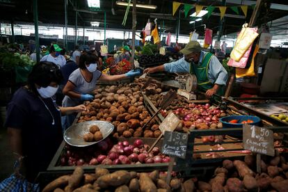 Un par de mujeres compran verdura en un mercado en Lima (Perú), en mayo de 2020.
