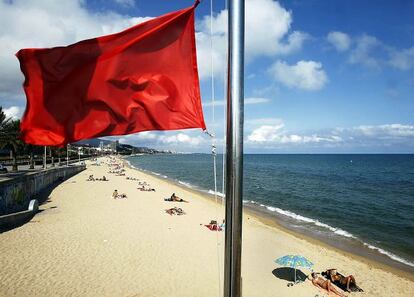 Una playa catalana con bandera roja.