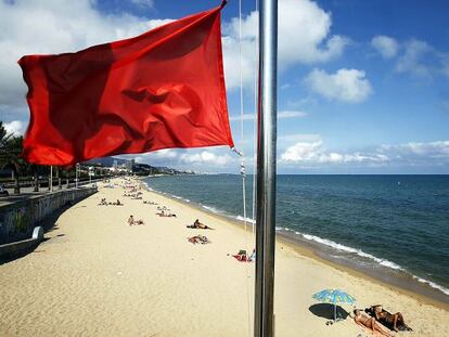 Una playa catalana con bandera roja.