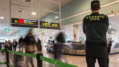 Un agente de la Guardia Civil vigila la recogida de equipajes en un aeropuerto español.