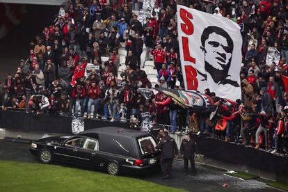 Un coche fúnebre pasa delante de las gradas con el ataúd del ídolo del fútbol portugués Eusébio en el Estadio de la Luz, donde lleva instalada desde ayer la capilla ardiente, en Lisboa, Portugal, 6 de enero de 2013.