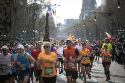 Els corredors al passeig de Gràcia. Un atleta carrega una torre Eiffel. 