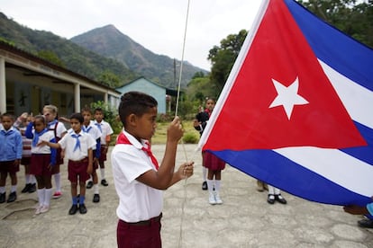 El gobierno cubano abrió instalaciones médicas, escuelas y caminos pavimentados a lugares remotos como Santo Domingo. En la imagen, un niño iza la bandera de Cuba en su colegio en Santo Domingo, en la Sierra Maestra (Cuba).