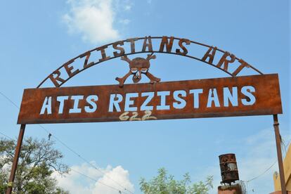 In this April 6, 2016 photo the metal archway of Atis Rezistans stands outside an open-air museum and art workshop off a trash-strewn street called Grand Rue in Port-au-Prince, Haiti. The site is in the yard of a founding member of a loose collective of Haitian artists who have become celebrated in the international art world by creating sculptures out of scrapped car parts, old wood, discarded toys and even human skulls found scattered outside crumbling mausoleums. (AP Photo/David McFadden)