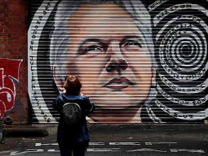 Uma mulher observa um mural com o rosto do jornalista Julian Assange nas ruas do Melbourne.