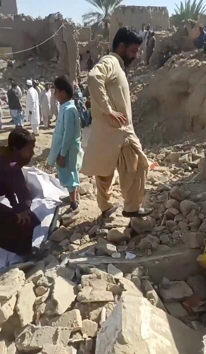 Varios hombres y niños inspeccionan los escombros de varios edificios atacados por un misil, el pasado día 18 en la ciudad iraní de Saravan.