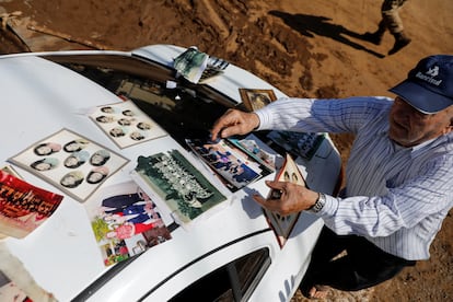Un hombre pone a secar fotografías familiares sobre el techo de su automóvil, en Muçum. 
