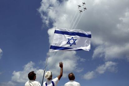 Tres israel&iacute;es observan un ejercicio militar a&eacute;reo el d&iacute;a de la independencia de Israel, el martes. 