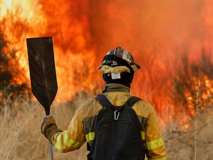 A firefighter stands as he battles a wildfire in Veiga das Meas, northwestern Spain, Saturday, Aug. 16, 2025. (AP Photo/Lalo R. Villar)