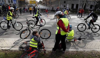 Niños y mayores en bici por el paseo del Prado.