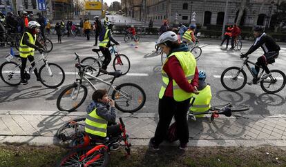 Niños y mayores en bici por el paseo del Prado.