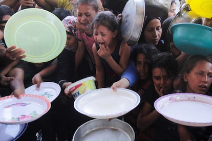Niños palestinos de la Franja de Gaza aguardan para recibir un plato de comida.