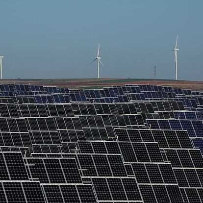 EL BONILLO, SPAIN - DECEMBER 02:  Photovoltaic power panels stand at Abaste's El Bonillo Solar Plant while wind turbines spin at a wind farm on the background on December 2, 2015 in El Bonillo, Albacete province, Spain. Spain in 2008 was a leading country on photovoltaic power and renewable energies but after some law changes the solar power industry collapsed, with companies either closing or turning to overseas markets. The UN Climate Change Summit is taking place in Paris over two weeks, in an attempt to agree on an international deal to curb greenhouse gas emissions.  (Photo by Pablo Blazquez Dominguez/Getty Images)