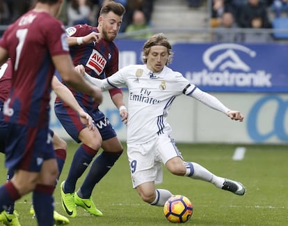 El centrocampista croata del Real Madrid, Luka Modric, disputa un balón con el delantero del Eibar, Sergi Enrich.