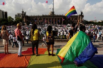 Varios activistas alzan banderas arcoiris en frente de miles de personas que protestan contra el matrimonio homosexual, en Monterrey.