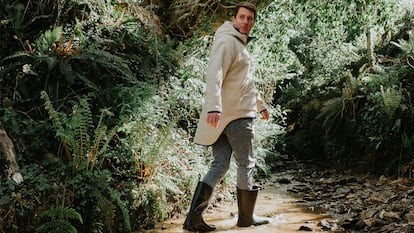 un hombre caminando con botas de agua sobre un riachuelo