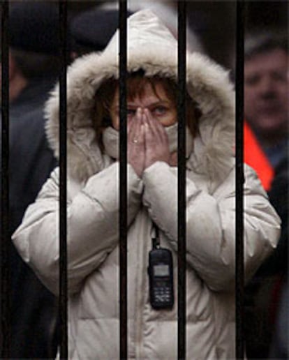 Una mujer se tapa la cara, horrorizada, ante las escenas dantescas que est contemplando frente a la puerta del teatro Dubrovka, mientras espera informacin sobre sus familares, sorprendidos en plena representacin por la accin de los terroristas, que a cambio de su libertad exigan el fin de la guerra en Chechenia.(REUTERS)