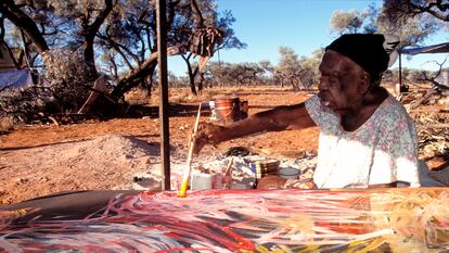 La artista Emily Kame Kngwarreye pinta uno de sus lienzos en la comunidad Utopia, en la Australia Central