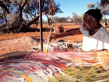 La artista Emily Kame Kngwarreye pinta uno de sus lienzos en la comunidad Utopia, en la Australia Central