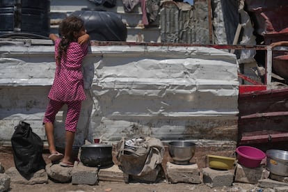 Una niña palestina espera para recibir alimentos en una cocina comunitaria en la ciudad de Gaza, este viernes.