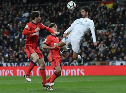 El jugador del Real Madrid Isco, cabecea un balón ante la oposición de Aritz Elustondo.