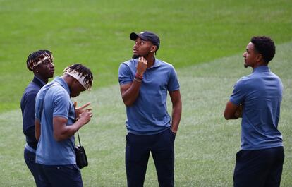 Nkunku, con gorra, durante la inspección del campo, este martes en el Bernabéu.