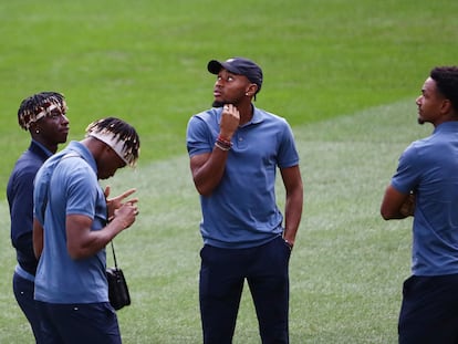 Nkunku, con gorra, durante la inspección del campo, este martes en el Bernabéu.