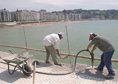 Dos operarios  prosiguen, ayer, con la construccin de la barandilla del Paseo de La Concha, tras el fin de la huelga.