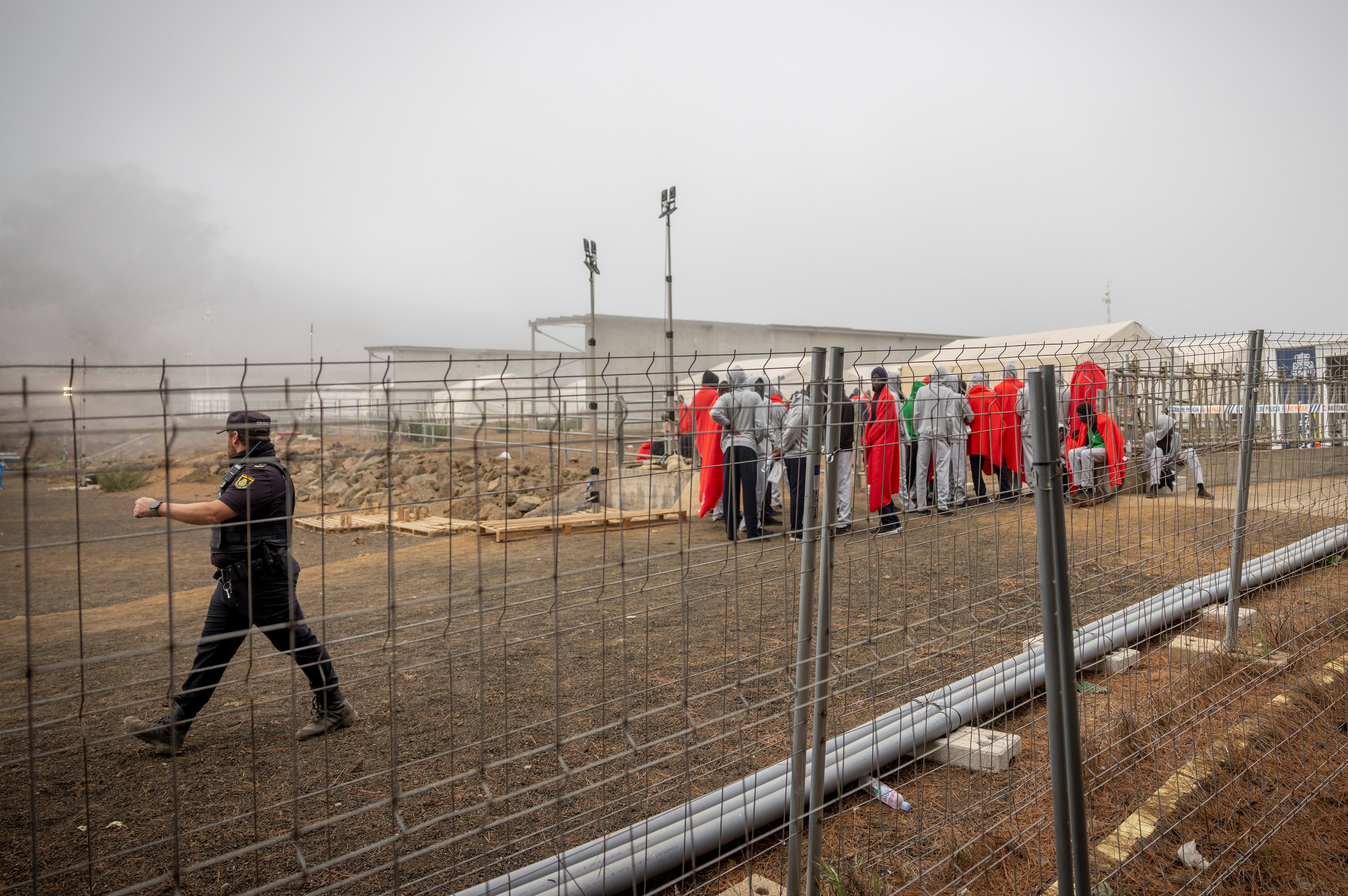 Un agente y un grupo de migrantes en el Centro de Atención Temporal de Extranjeros (CATE), ubicado en San Andrés (El Hierro).