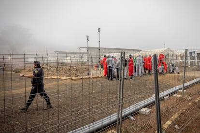 Un agente y un grupo de migrantes llegados El Hierro el martes día 1 en el Centro de Atención Temporal de Extranjeros (CATE), ubicado en San Andrés (El Hierro).