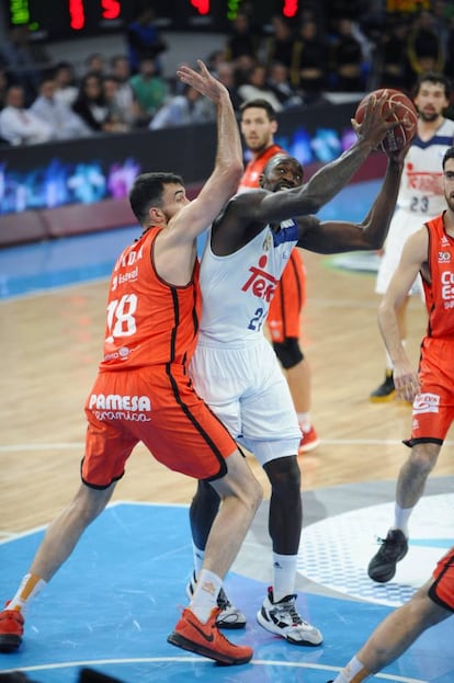 El pivot estadounidense del Real Madrid, Othello Hunter (d), intenta superar la defensa del jugador del Valencia Basket, Pierrer Oriola.
