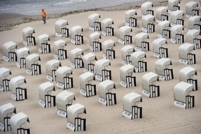 Un hombre camina entre las sillas de playa en Sellin, Alemania.