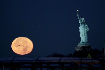 La Superluna junto a la Estatua de la Libertad, en Nueva York (Estados Unidos).