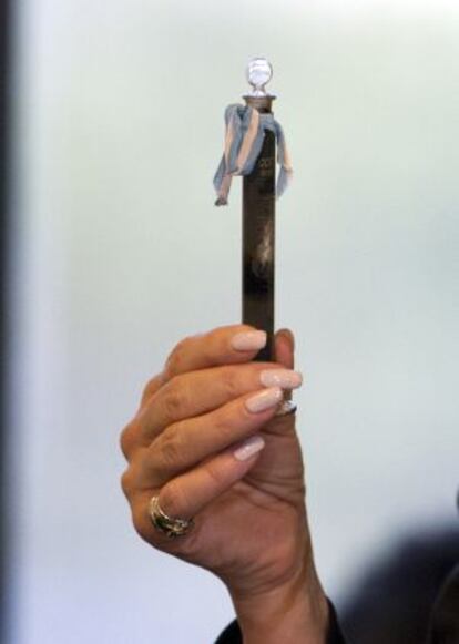 La mano de la presidenta de Argentina sujetando un tubo con una muestra de petróleo de YPF.
